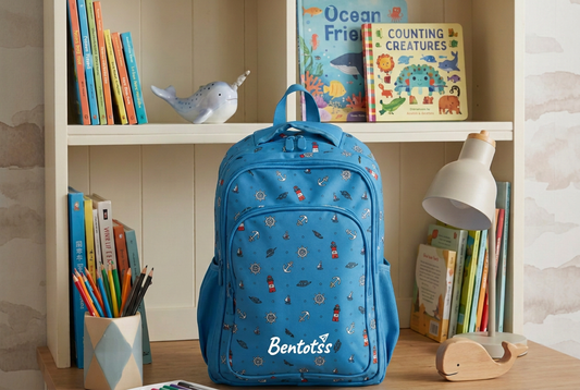 Cyan Blue nautical-print kids backpack with white Bentotss logo on a study desk