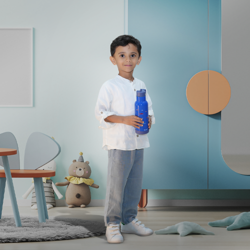Boy holding Cosmic Carry blue space themed sipper bottle indoors lightweight and easy to grip