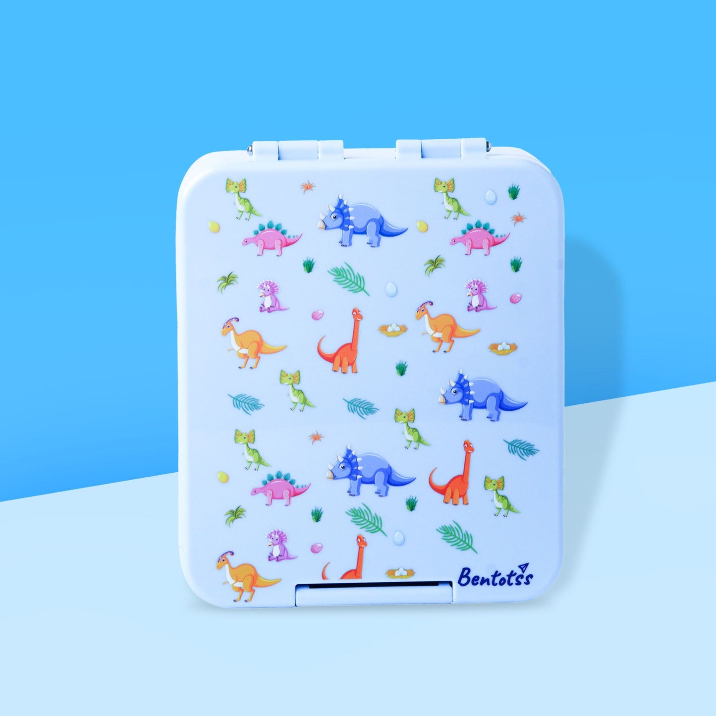 Bento kids lunchbox with dinosaur prints in light blue by Bentotss, placed on a blue background