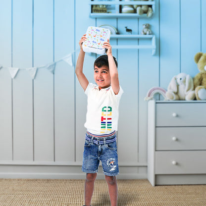 Boy holding up the Bento dinosaur themed lunchbox by Bentotss in a bright room setting