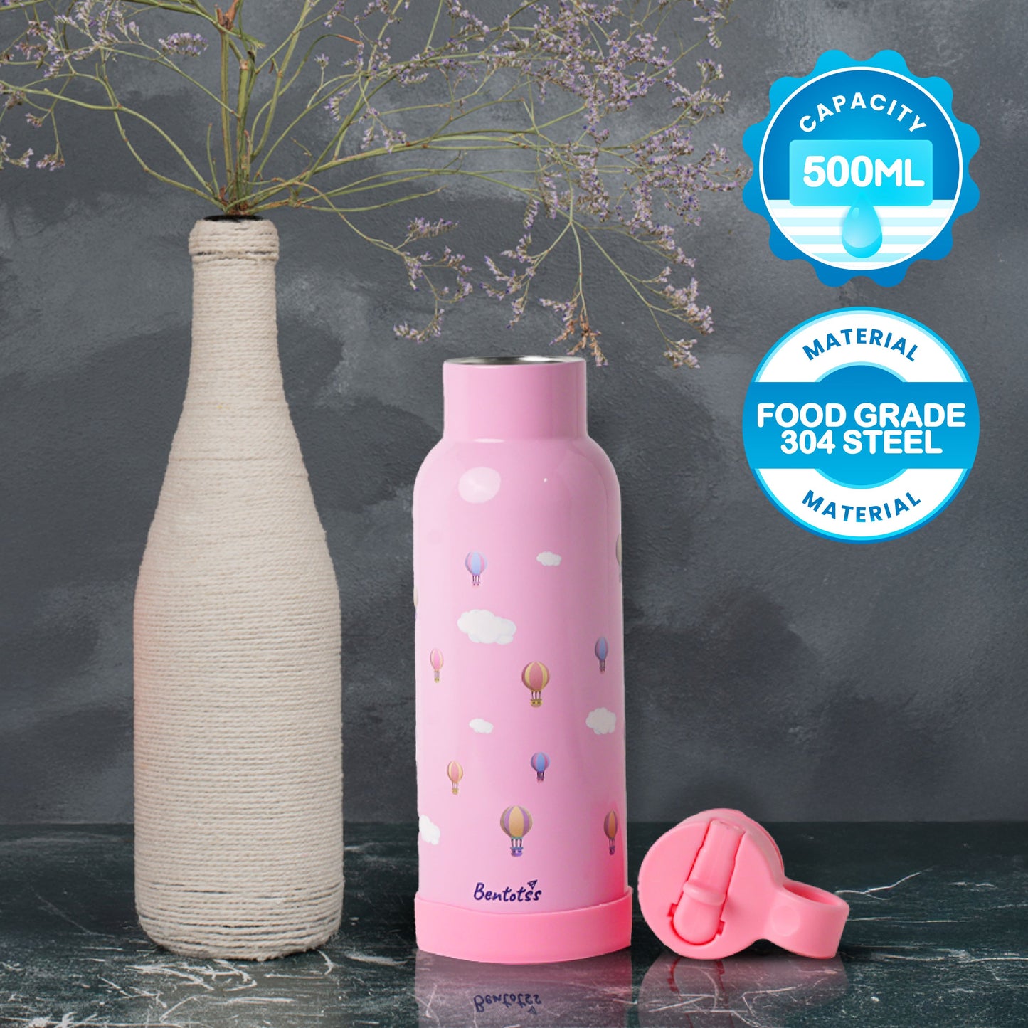 Bentoyss stainless steel pink water bottle shown next to two ceramic vases, highlighting its 500ml capacity and dual-wall insulation