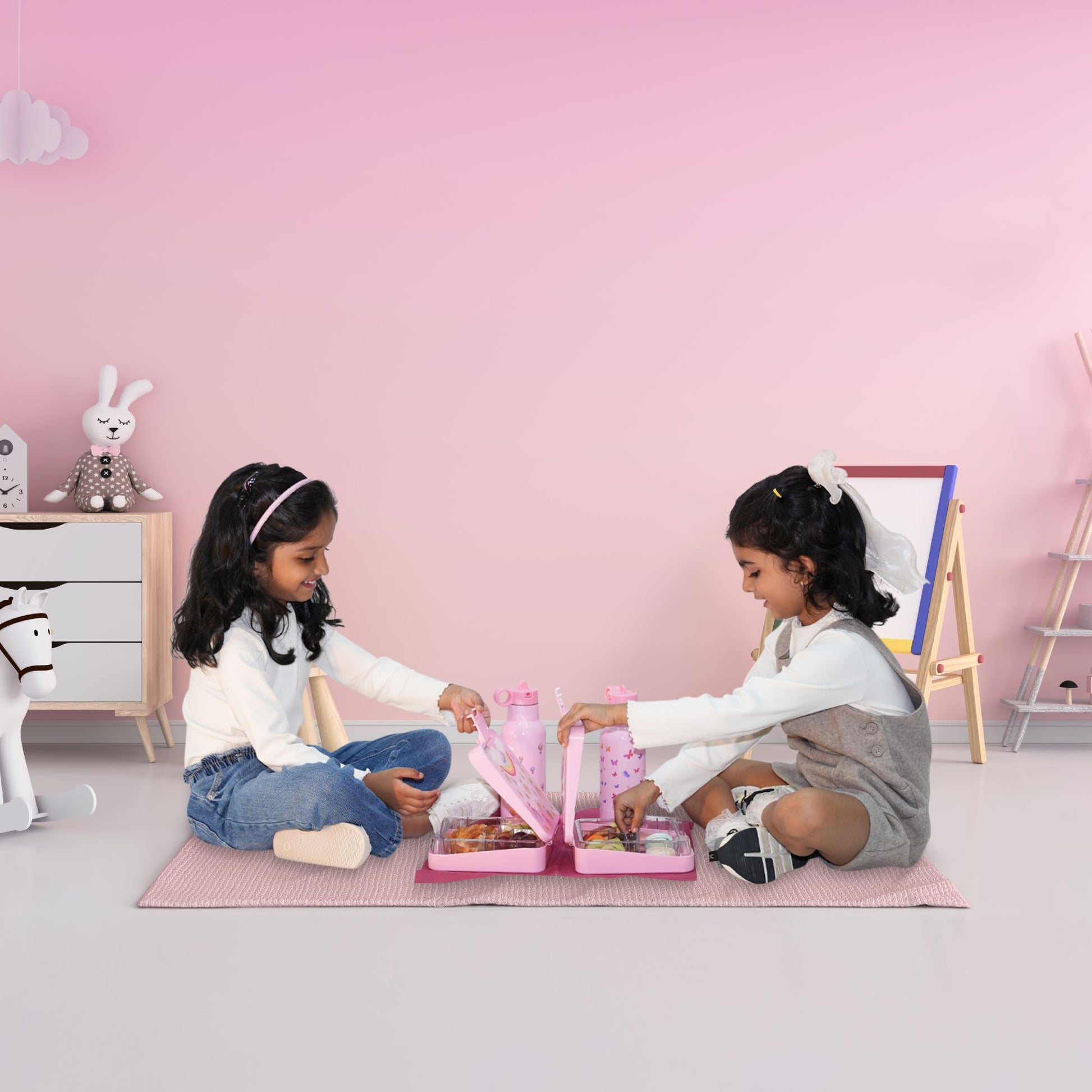 Two girls happily playing together on the floor with the Bentotss Butterfly Magic Bento Box set